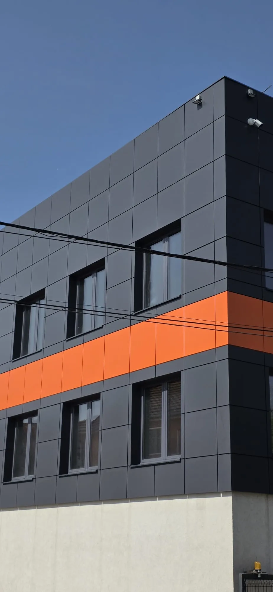 Završena ventilisana fasada poslovnog objekta sa tamnosivim i narandžastim Alukobond panelima